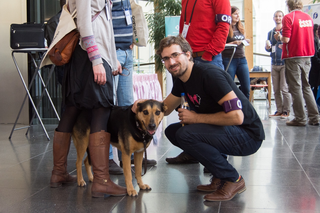 Tomáš Ehrlich smiling while petting a dog